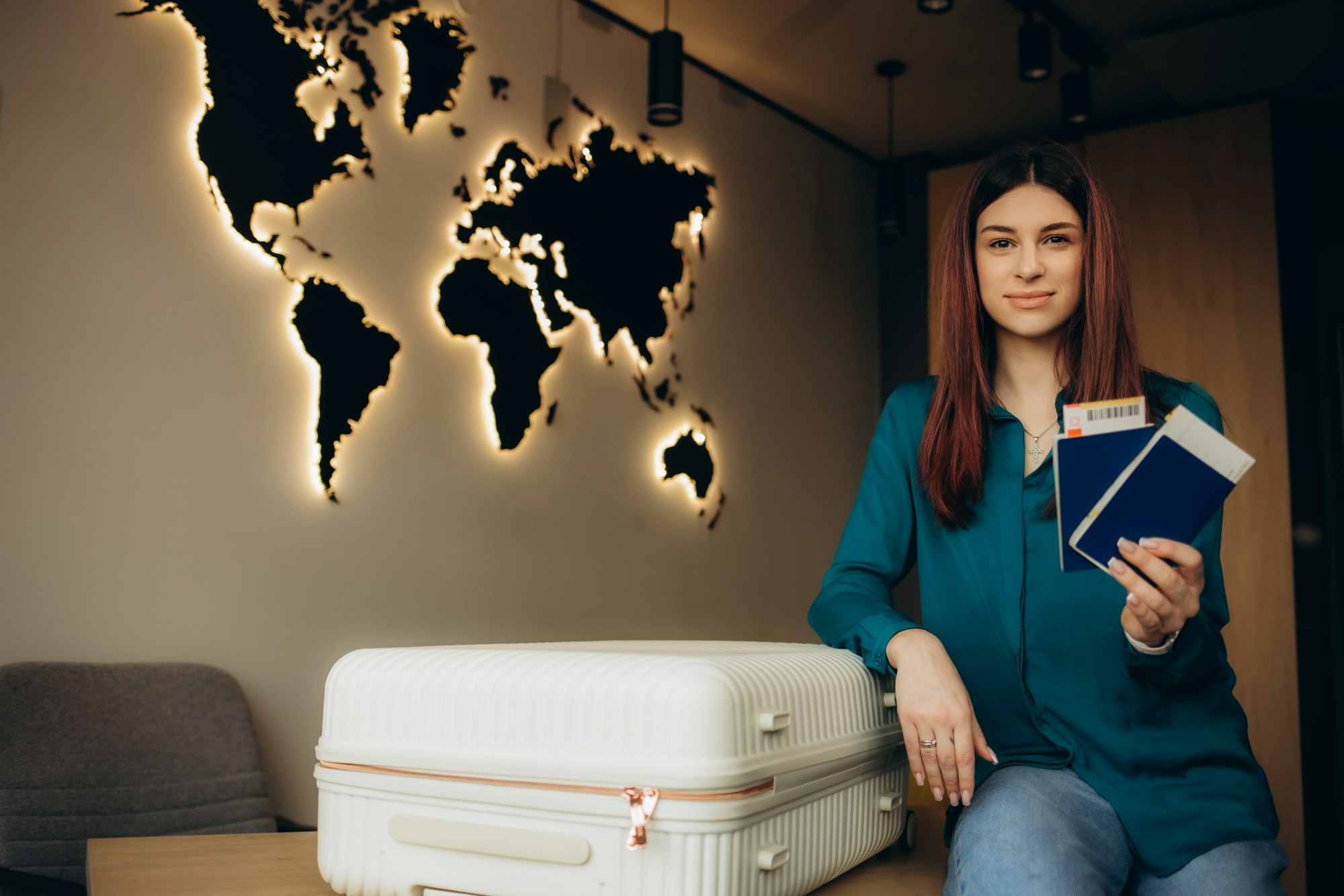 a woman with a suitcase and a passport with tickets in a travel agency