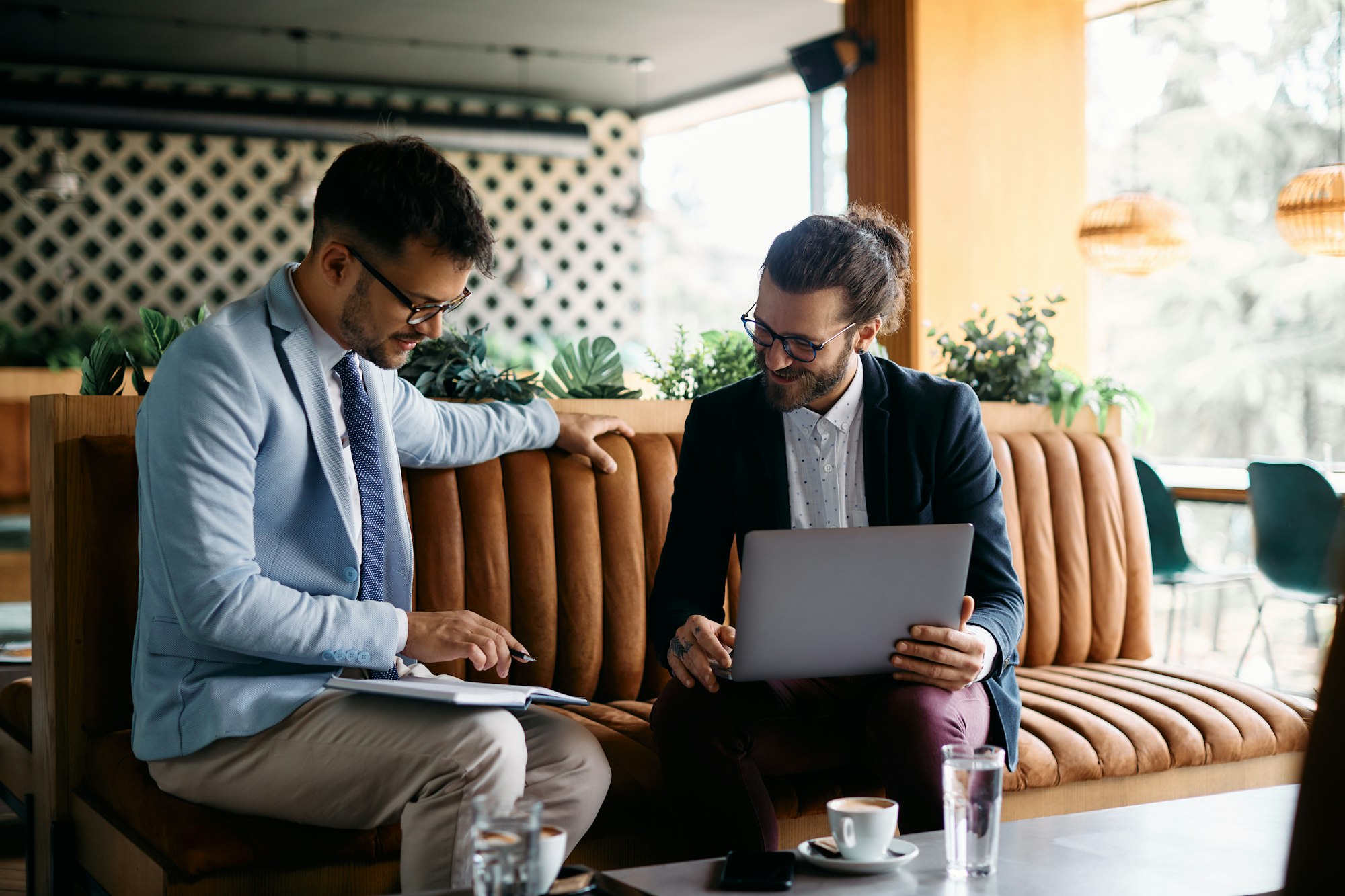 Happy entrepreneurs cooperating while working during business meeting in a cafe. Trade secrets LAW in UAE