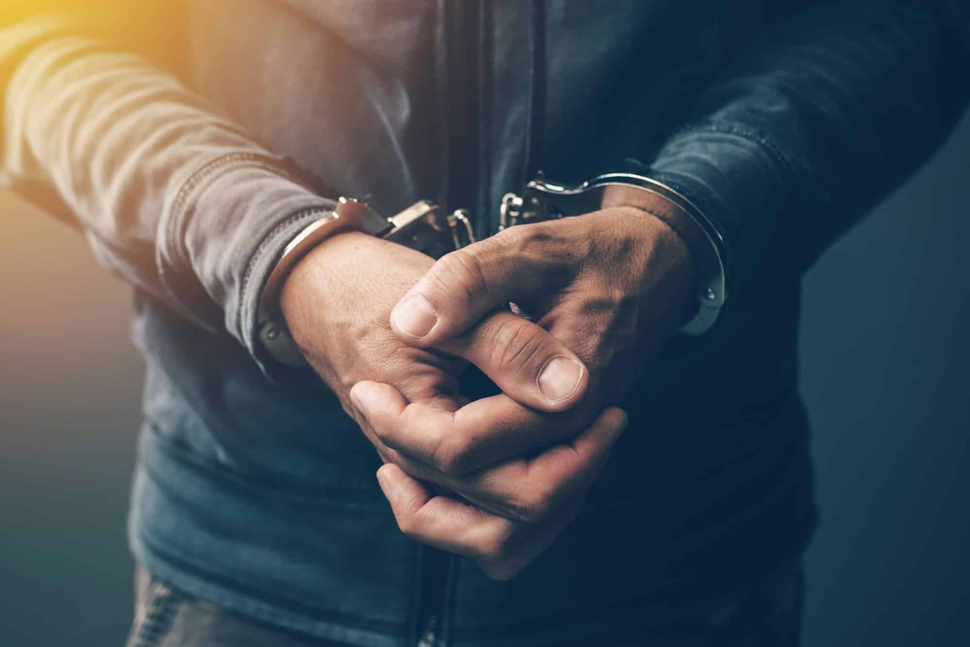 Arrested computer hacker with handcuffs UAE arrest, arrested in UAE, UAE arrest warrant