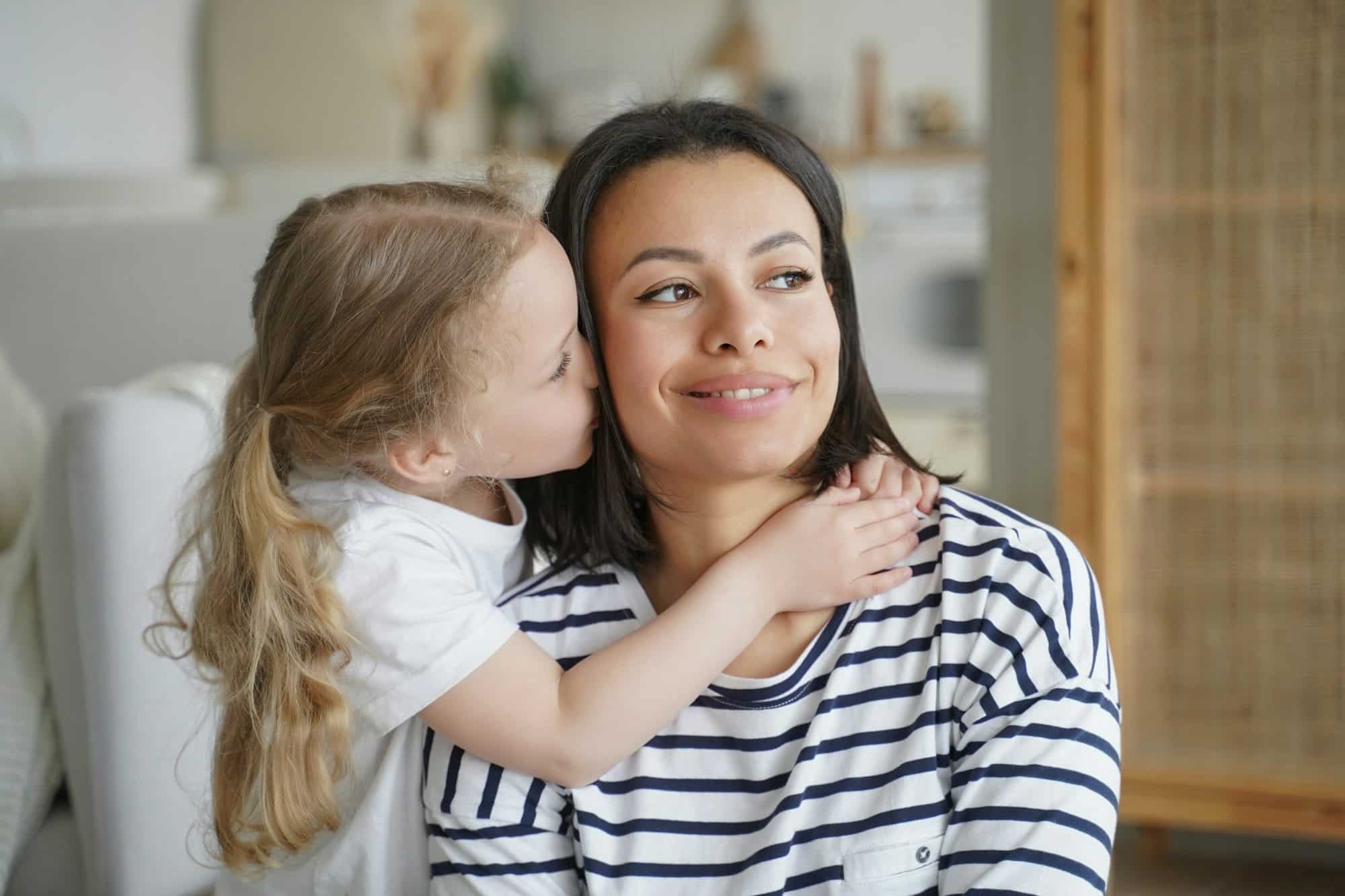Loving adopted daughter hugs, kissing foster mom. Happy motherhood, custody of child girl, adoption Child Custody in UAE: Laws for Non-Muslim Women Post-Divorce